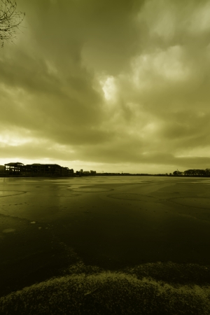 extremely gloomy weather, frozen river in a parkの写真素材