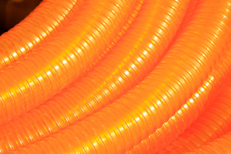 orange plastic pipe stacked toghter at a construction site