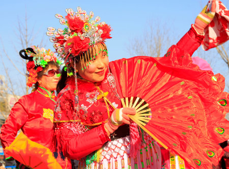 LUANNAN COUNTY - FEBRUARY 9: People wearing colorful clothes, performing yangko dance in the street, during the Chinese Lunar New Year, February 9, 2014, Luannan County, Hebei Province, China.のeditorial素材