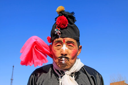 LUANNAN COUNTY - FEBRUARY 9: Buffoon wearing colorful clothes, performing yangko dance in the street, during the Chinese Lunar New Year, February 9, 2014, Luannan County, Hebei Province, China.のeditorial素材