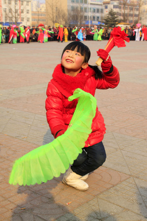 LUANNAN COUNTY - FEBRUARY 12: Girl wearing colorful clothes, performing yangko dance in the street, during the Chinese Lunar New Year, February 12, 2014, Luannan County, Hebei Province, China.のeditorial素材