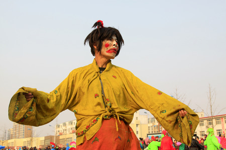 LUANNAN COUNTY - FEBRUARY 13: Buffoon wearing colorful clothes, performing yangko dance in the street, during the Chinese Lunar New Year, February 13, 2014, Luannan County, Hebei Province, China.のeditorial素材