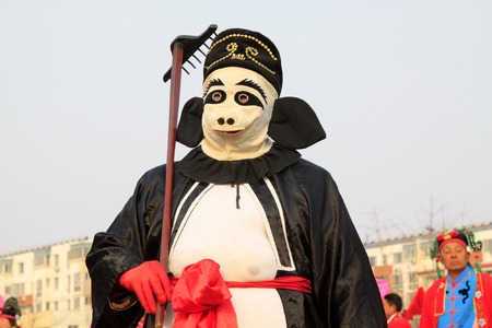 LUANNAN COUNTY - FEBRUARY 13: Zhu bajie's image wearing colorful clothes, performing yangko dance in the street, during the Chinese Lunar New Year, February 13, 2014, Luannan County, Hebei Province, China.のeditorial素材