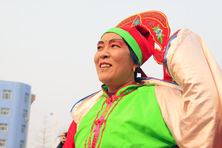 LUANNAN COUNTY - FEBRUARY 15: Woman wearing colorful clothes, performing yangko dance in the street, during the Chinese Lunar New Year, February 15, 2014, Luannan County, Hebei Province, China.のeditorial素材