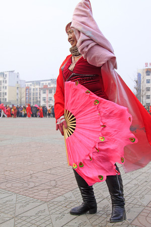 LUANNAN COUNTY - FEBRUARY 15: Young woman wearing colorful clothes, performing yangko dance in the street, during the Chinese Lunar New Year, February 15, 2014, Luannan County, Hebei Province, China.のeditorial素材