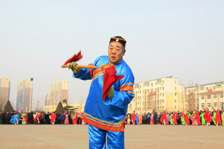LUANNAN COUNTY - FEBRUARY 12: Old man holding pairs of wooden stick performing yangko dance in the street, during the Chinese Lunar New Year, February 12, 2014, Luannan County, Hebei Province, China.のeditorial素材