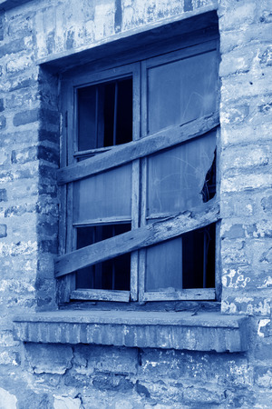 broken and closed wooden windows in a deserted placeの写真素材