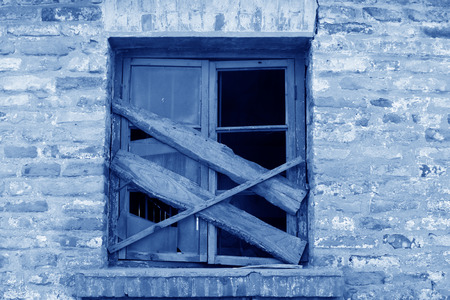 broken and closed wooden windows in a deserted placeの写真素材