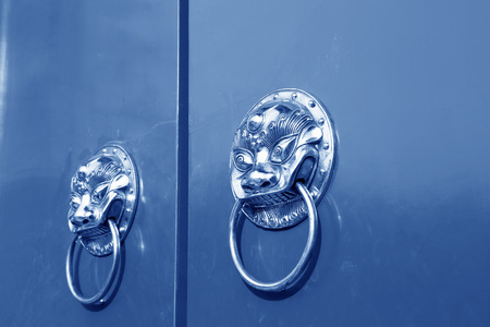 traditional Chinese style metal knocker on the door in the Jingshan Park, beijing, chinaの写真素材