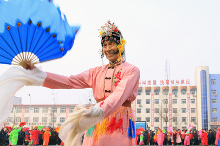 LUANNAN COUNTY - FEBRUARY 15: Old man wearing colorful clothes, performing yangko dance in the street, during the Chinese Lunar New Year, February 15, 2014, Luannan County, Hebei Province, China.のeditorial素材