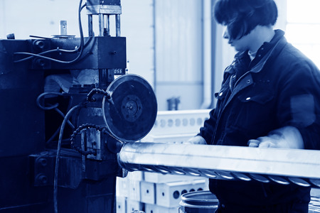 TANGSHAN - DECEMBER 22: The worker in operating machinery on the production line, in a solar equipment production workshop on december 22, 2013, tangshan, china.のeditorial素材