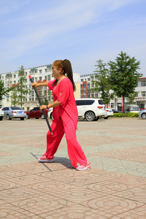 LUANNAN COUNTY - JUNE 29: woman in red was performing stick fencing in the square, on june 29, 2014, LuanNan county, hebei province, China 
のeditorial素材