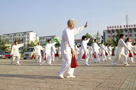 LUANNAN COUNTY - JUNE 14: A group of old people were performing Tai chi chuan on the gym in the square, on june 14, 2014, LuanNan county, hebei province, China 
 のeditorial素材