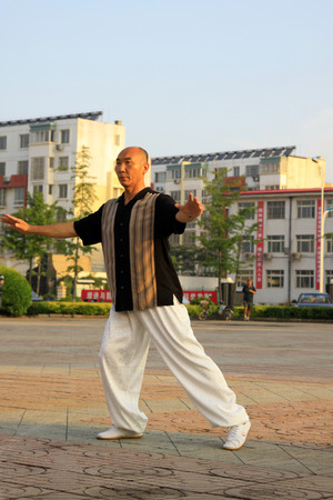 LUANNAN COUNTY - JUNE 14: A man was performing Tai chi chuan on the gym in the square, on june 14, 2014, LuanNan county, hebei province, China 
のeditorial素材