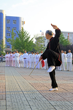 LUANNAN COUNTY - JUNE 14: An old man was performing Taiji sword on the gym in the square, on june 14, 2014, LuanNan county, hebei province, China 
のeditorial素材