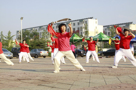 LUANNAN COUNTY - JUNE 14: A group of people were performing Tai chi chuan on the gym in the square, on june 14, 2014, LuanNan county, hebei province, China 
 のeditorial素材