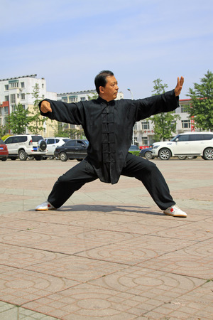 LUANNAN COUNTY - JUNE 29: man in black was performing shadowboxing in the square, on june 29, 2014, LuanNan county, hebei province, China 
のeditorial素材