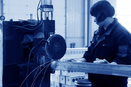 TANGSHAN - DECEMBER 22: The worker in operating machinery on the production line, in a solar equipment production workshop on december 22, 2013, tangshan, china.のeditorial素材