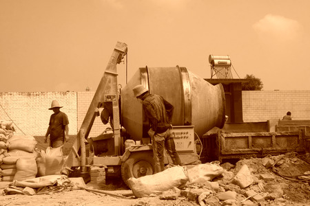 LUANNAN COUNTY - AUGUST 15: bags of cement and concrete mixer in the construction site, on august 15, 2014, Luannan County, Hebei Province, China 
のeditorial素材
