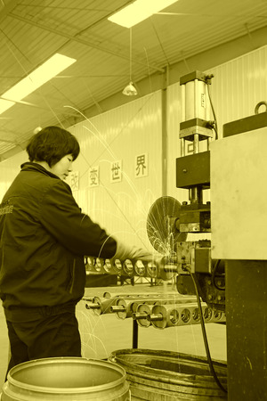 TANGSHAN - DECEMBER 22: The worker in operating machinery on the production line, in a solar equipment production workshop on december 22, 2013, tangshan, china.のeditorial素材