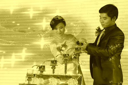 LUANNAN COUNTY - DECEMBER 29: The bride and groom pour a wine together on the dining table, traditional customs in chinese wedding, on december 29, 2013, Luannan County, Hebei Province, China.のeditorial素材