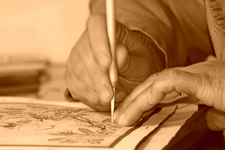 the hands using knives make paper-cut works, closeup of photoの写真素材