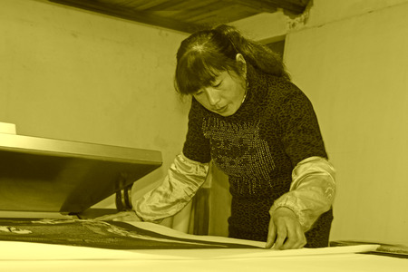 FUCHENG - DECEMBER 8: The female workman was framing paper-cut works, on december 8, 2013, fucheng, hebei province, China.のeditorial素材