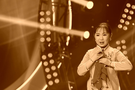 LUANNAN COUNTY - JANUARY 4: The girl dressed in red singing PingJu on the stage, in the ChengZhaoCai grand theater, January 4, 2014,luannan county, hebei province, china.のeditorial素材