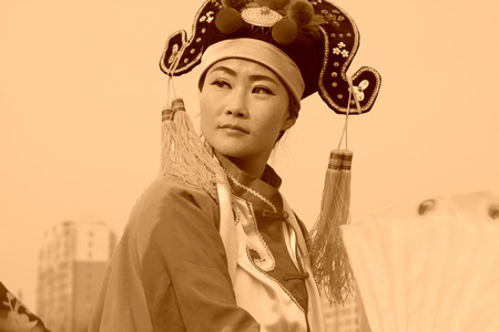 LUANNAN COUNTY - FEBRUARY 12: Young woman wearing colorful clothes, performing yangko dance in the street, during the Chinese Lunar New Year, February 12, 2014, Luannan County, Hebei Province, China.のeditorial素材