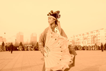 LUANNAN COUNTY - FEBRUARY 12: Young woman wearing colorful clothes, performing yangko dance in the street, during the Chinese Lunar New Year, February 12, 2014, Luannan County, Hebei Province, China.のeditorial素材