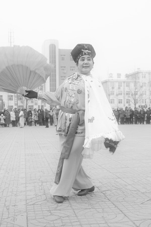 LUANNAN COUNTY - FEBRUARY 15: Old woman wearing colorful clothes, performing yangko dance in the street, during the Chinese Lunar New Year, February 15, 2014, Luannan County, Hebei Province, China.のeditorial素材