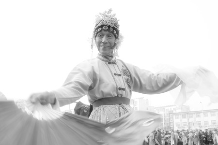 LUANNAN COUNTY - FEBRUARY 15: Old man wearing colorful clothes, performing yangko dance in the street, during the Chinese Lunar New Year, February 15, 2014, Luannan County, Hebei Province, China.のeditorial素材