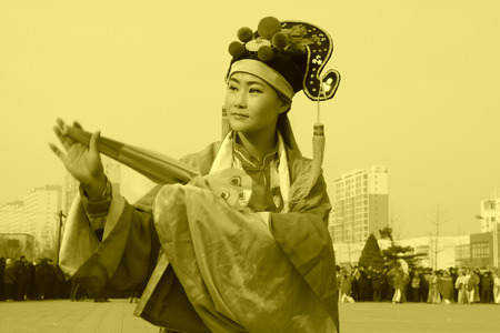 LUANNAN COUNTY - FEBRUARY 12: Young woman wearing colorful clothes, performing yangko dance in the street, during the Chinese Lunar New Year, February 12, 2014, Luannan County, Hebei Province, China.のeditorial素材