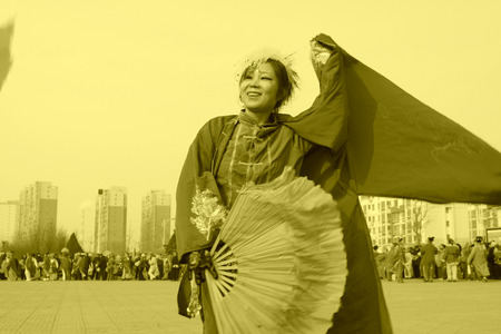 LUANNAN COUNTY - FEBRUARY 13: Young woman wearing colorful clothes, performing yangko dance in the street, during the Chinese Lunar New Year, February 13, 2014, Luannan County, Hebei Province, China.のeditorial素材