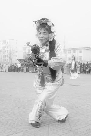 LUANNAN COUNTY - FEBRUARY 15: Woman holding pairs of wooden stick performing yangko dance in the street, during the Chinese Lunar New Year, February 15, 2014, Luannan County, Hebei Province, China.のeditorial素材