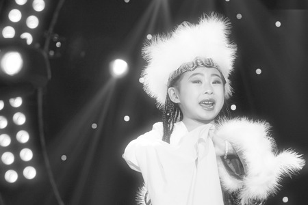 LUANNAN COUNTY - JANUARY 6: The little girl dressed in gorgeous dress performing PingJu on the stage, in the ChengZhaoCai grand theater, January 6, 2014,luannan county, hebei province, china.のeditorial素材