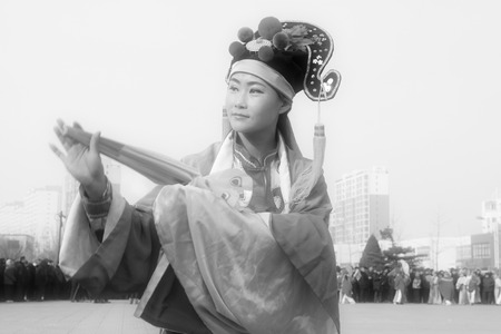 LUANNAN COUNTY - FEBRUARY 12: Young woman wearing colorful clothes, performing yangko dance in the street, during the Chinese Lunar New Year, February 12, 2014, Luannan County, Hebei Province, China.のeditorial素材