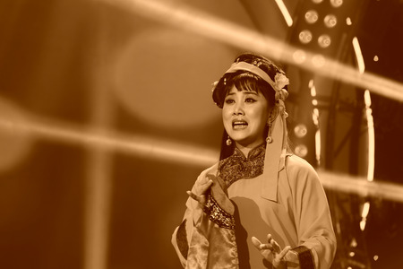 LUANNAN COUNTY - JANUARY 4: The girl dressed in tsing clothes singing PingJu on the stage, in the ChengZhaoCai grand theater, January 4, 2014,luannan county, hebei province, china.のeditorial素材