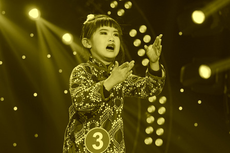 LUANNAN COUNTY - JANUARY 6: The girl dressed in blue singing PingJu on the stage, in the ChengZhaoCai grand theater, January 6, 2014,luannan county, hebei province, china.のeditorial素材
