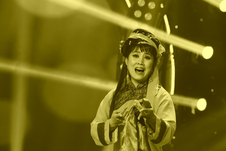 LUANNAN COUNTY - JANUARY 4: The girl dressed in tsing clothes singing PingJu on the stage, in the ChengZhaoCai grand theater, January 4, 2014,luannan county, hebei province, china.のeditorial素材