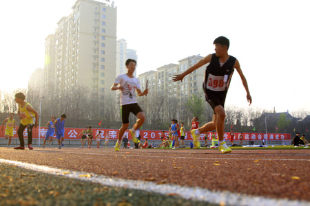 LUANNAN COUNTY - APRIL 14: 400 meter relay runner at the sports meeting, April 14, 2015, Luannan County, Hebei Province, Chinaのeditorial素材