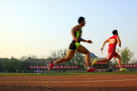 LUANNAN COUNTY - APRIL 14: 400 meter relay runner at the sports meeting, April 14, 2015, Luannan County, Hebei Province, Chinaのeditorial素材