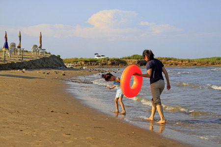 JINGTANG PORT - AUGUST 29: A mother and daughter playing nearby the sea beach, on August 29, 2015, Jingtang Port, hebei province, China.のeditorial素材