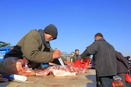 Luannan County - February 1: customers buying pork in the rural market, February 1, 2016, luannan county, hebei province, China.のeditorial素材