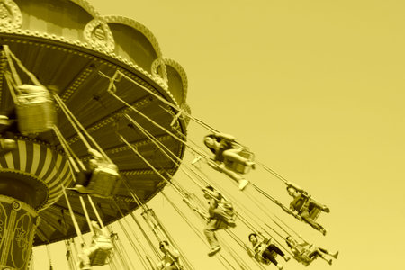 people on rotating facilities in a playground, closeup of photoのeditorial素材