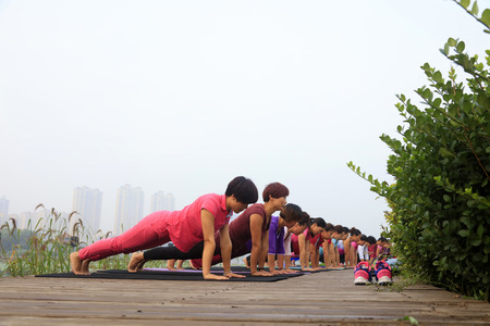 Tangshan City - September 4: women doing yoga exercise in the park, on September 4, 2016, tangshan city, hebei province, China.のeditorial素材