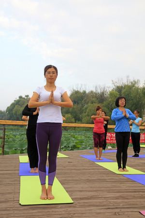 Tangshan City - September 3: women doing yoga exercise in the park, on September 3, 2016, tangshan city, hebei province, China.のeditorial素材