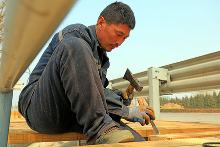 Luannan County - March 26, 2018: workers are processing wood planks in the outdoors, Luannan County,...