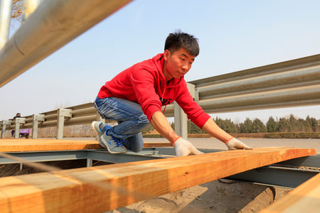 Luannan County - March 26, 2018: workers are processing wood planks in the outdoors, Luannan County, Hebei Province, Chinaのeditorial素材