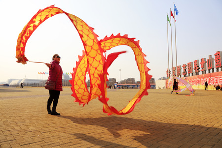 Tangshan City - February 20, 2018: people are dancing in colored silk for exercise in parks, Tangshan City, Hebei, China.のeditorial素材